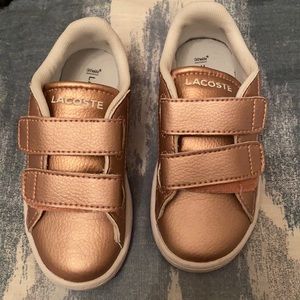 Rose gold Lacoste runners.